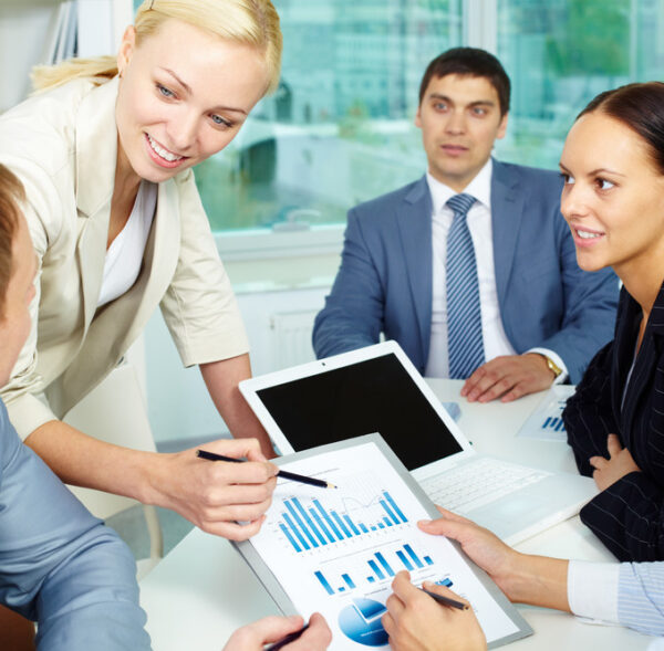 Group of business people discussing papers or sharing ideas in office